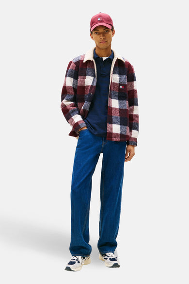 Multikleurig geruit overhemd van TOMMY JEANS met imitatiebont voering, gedragen met een marineblauw poloshirt en een blauwe jeans.