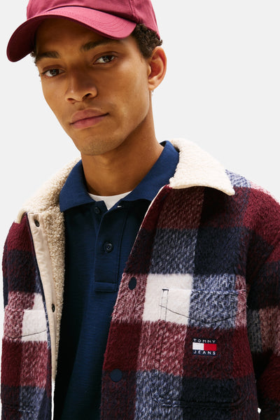 Chemise à carreaux multicolore de Tommy Jeans avec col en fausse fourrure et polo bleu marine porté en dessous.