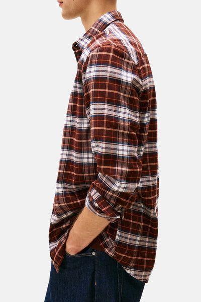 Chemise à manches longues marron by TOMMY JEANS avec motif à carreaux, portée avec un jean foncé, vue de côté.
