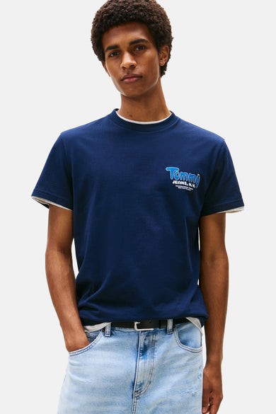 Blauw T-shirt met korte mouwen van TOMMY JEANS, met logo opdruk op de voorkant, gedragen met een lichte spijkerbroek.