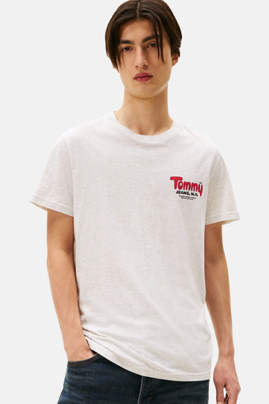 Grijze gemêleerde T-shirt met korte mouwen van Tommy Jeans, met rood logo op de voorkant en gedragen met een donkerblauwe jeans.