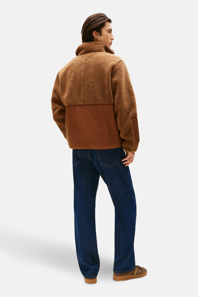 Veste marron en polaire par TOMMY JEANS, avec empiècement matelassé et porté avec un jean bleu et des chaussures marron.