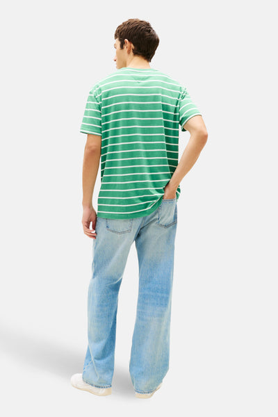 T-shirt à manches courtes vert à rayures blanches de TOMMY JEANS, porté avec un jean bleu ample.