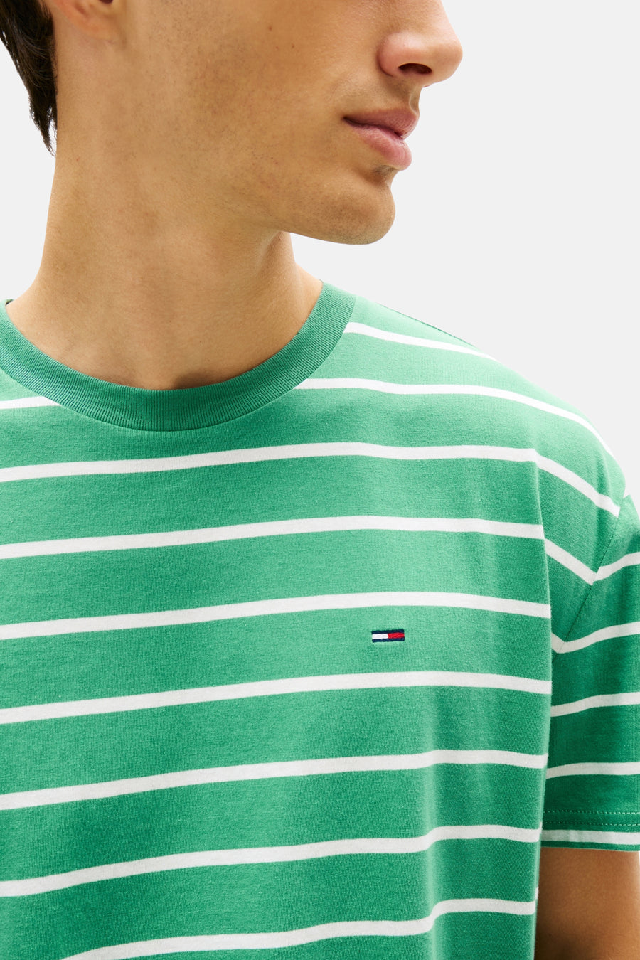 T-shirt à manches courtes vert de TOMMY JEANS, rayures blanches horizontales et logo sur la poitrine.