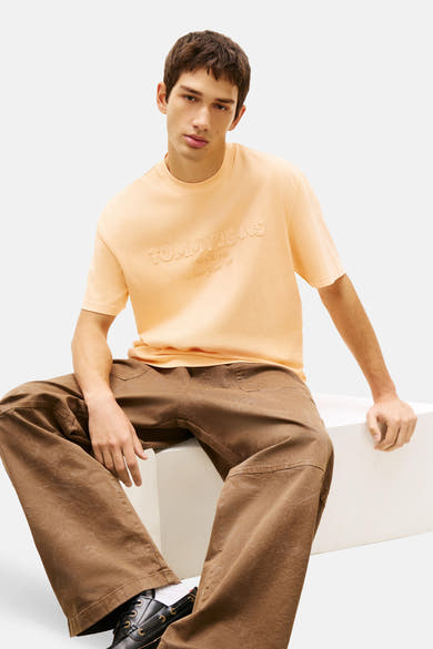 T-shirt orange à manches courtes de TOMMY JEANS, avec logo en relief sur le devant.