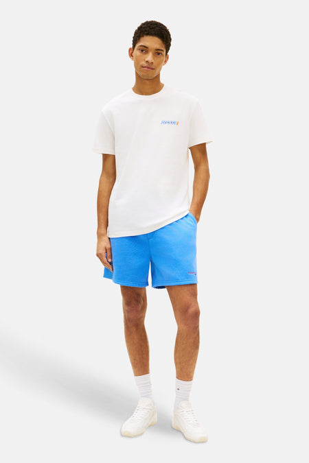 T-shirt blanc à manches courtes de TOMMY JEANS, avec un logo bleu et orange sur la poitrine.