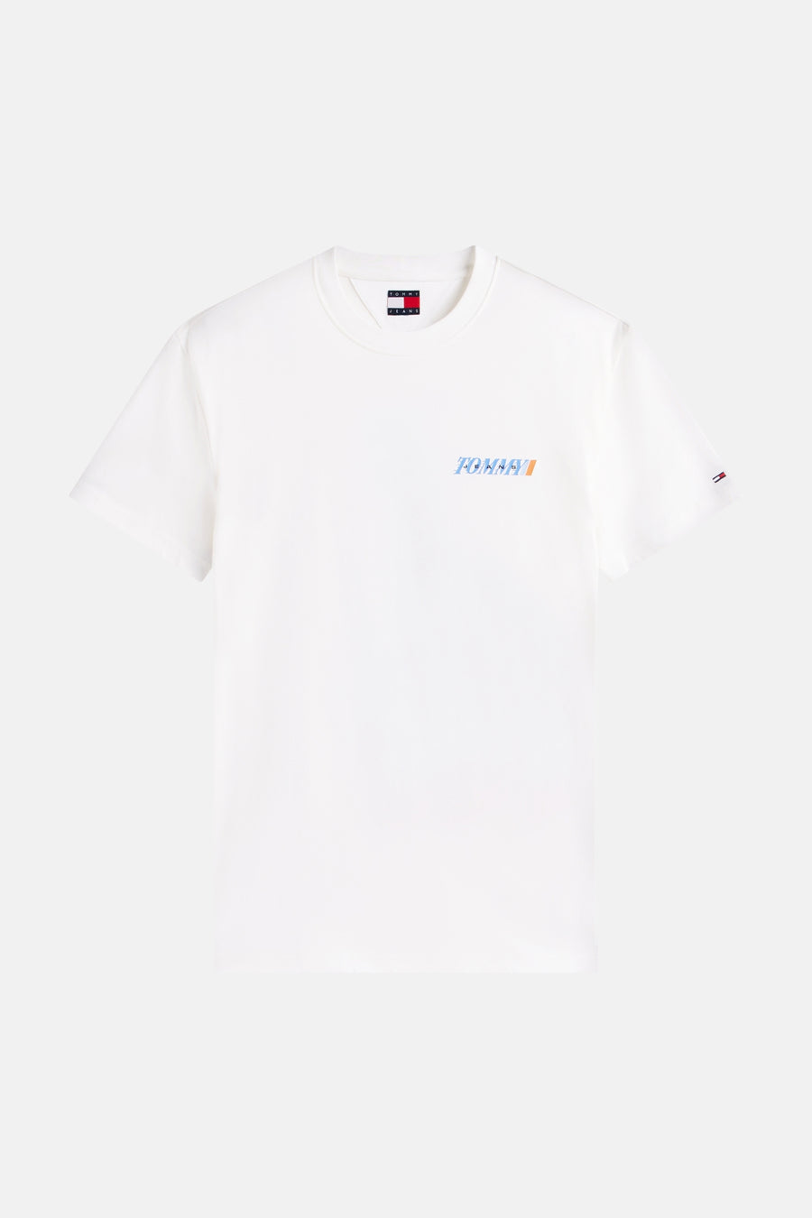 T-shirt blanc à manches courtes de TOMMY JEANS, avec un logo bleu et orange sur la poitrine et un petit drapeau sur la manche.