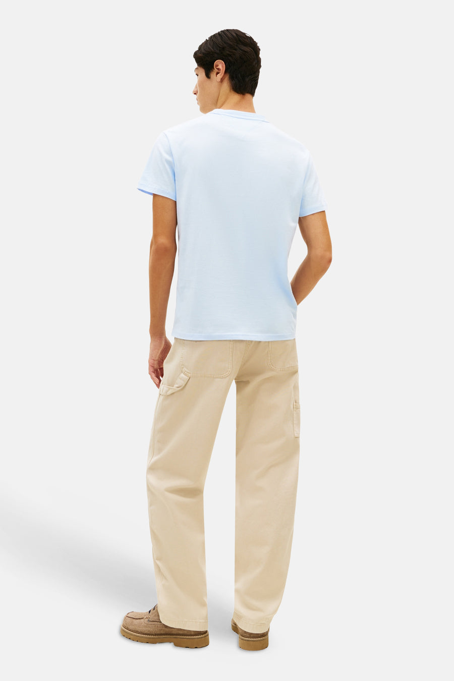 Blauw T-shirt met korte mouwen van TOMMY JEANS, gedragen met een beige broek en bruine schoenen, van achteren gezien.