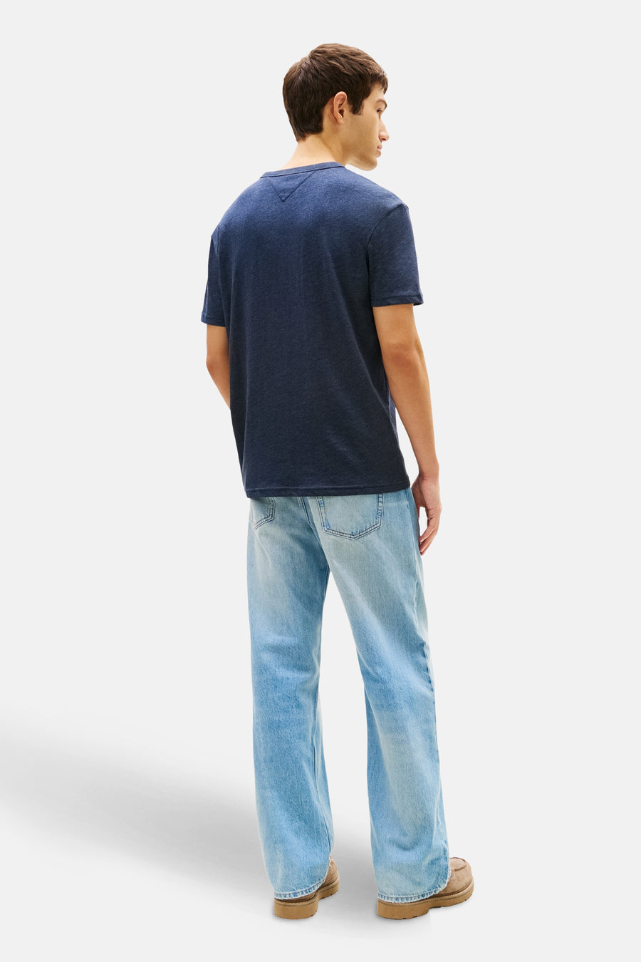Blauw T-shirt met korte mouwen van TOMMY JEANS, gedragen met een wijde, uitgewassen spijkerbroek, achtergezicht.