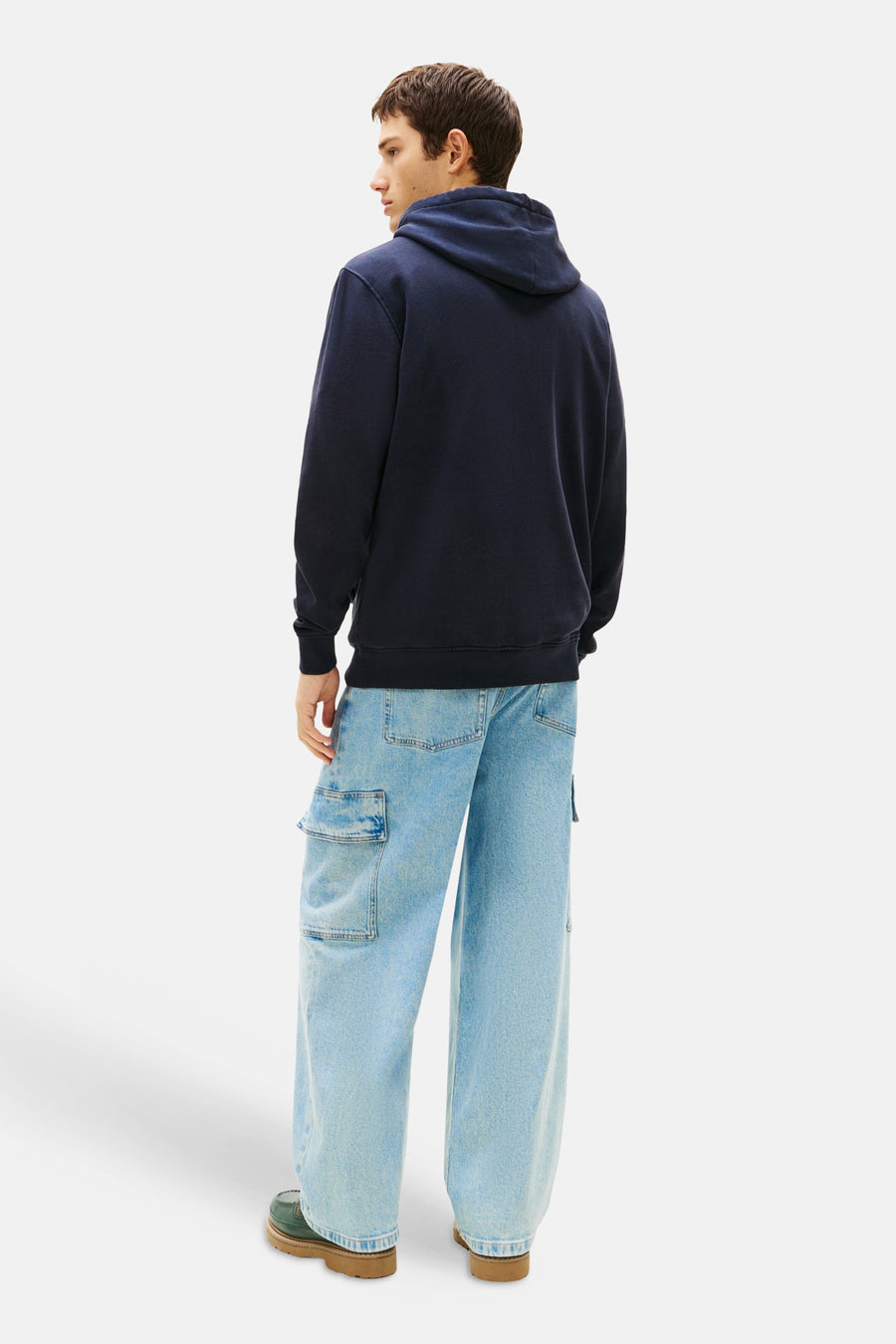Blauwe hoodie van TOMMY JEANS, met een capuchon en gedragen met een casual cargobroek.