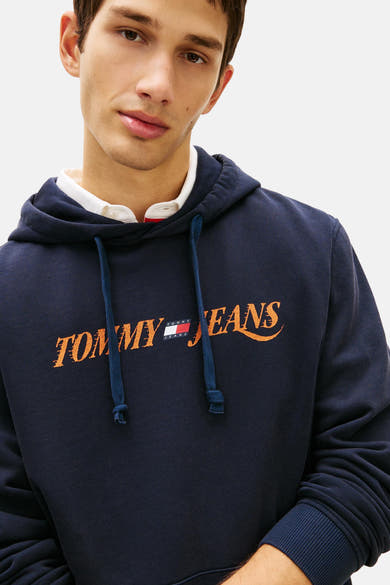 Blauwe hoodie van TOMMY JEANS, met oranje logo op de voorkant gedrukt, blauw trekkoord.