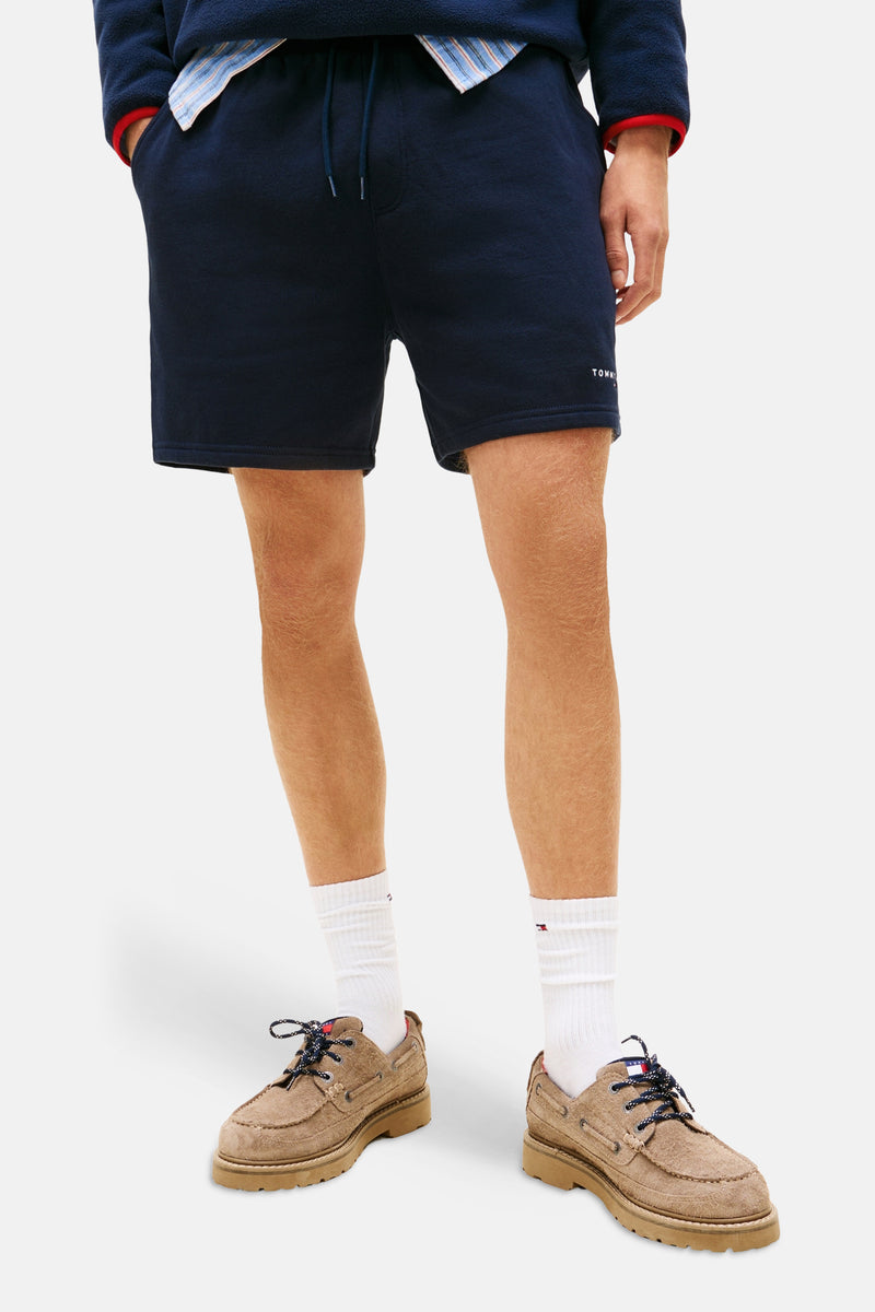 Short bleu marine TOMMY JEANS, porté avec des chaussures bateau en daim et chaussettes blanches.