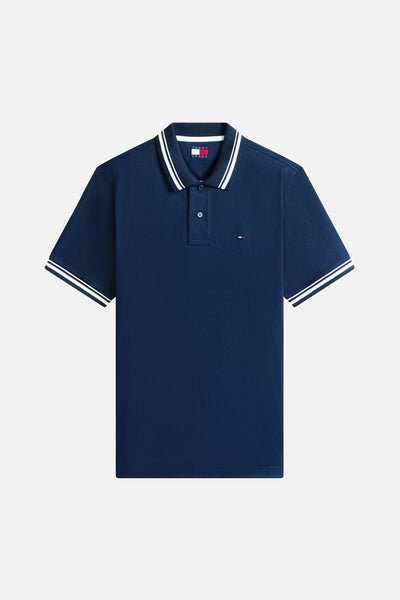 Polo bleu à manches courtes de Tommy Jeans, avec col et bordures de manches rayés blancs.