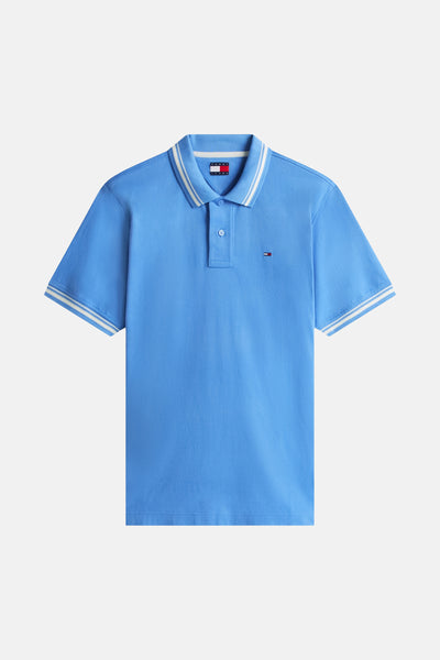 Blauwe polo van TOMMY JEANS met witte strepen op de kraag en korte mouwen.