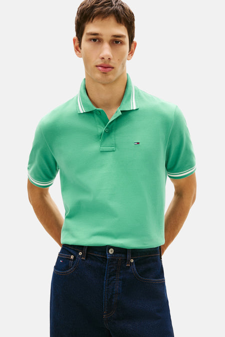 Groen poloshirt van TOMMY JEANS, met witte streepdetails op de kraag en korte mouwen.