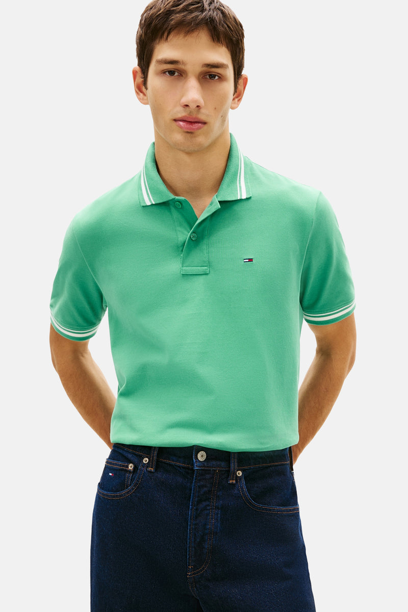 Groen poloshirt van TOMMY JEANS, met witte streepdetails op de kraag en korte mouwen.