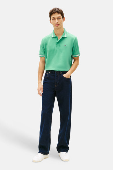 Polo vert de TOMMY JEANS, avec des détails rayés blancs sur le col et les manches courtes.