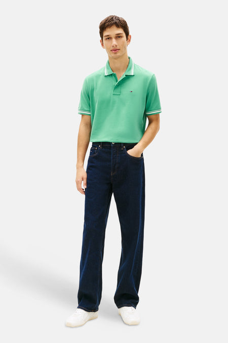 Polo vert de TOMMY JEANS, avec des détails rayés blancs sur le col et les manches courtes.