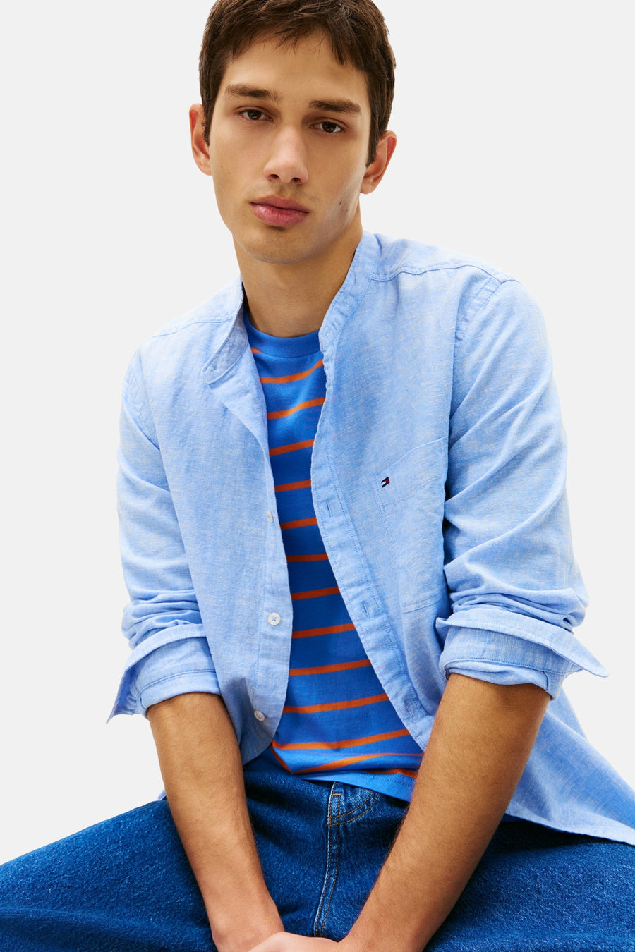 Blauw overhemd met lange mouwen van TOMMY JEANS, gedragen open over een gestreept T-shirt en een blauwe jeans