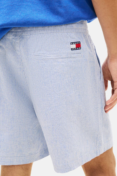 Korte blauwe gestreepte short van TOMMY JEANS, met een paspelzak achter en het merklogo.