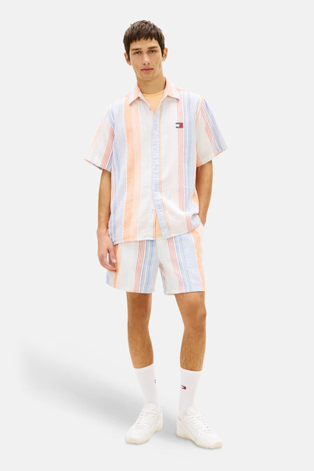 Short rayé orange de TOMMY JEANS avec chemise rayée assortie, chaussettes blanches et baskets blanches.