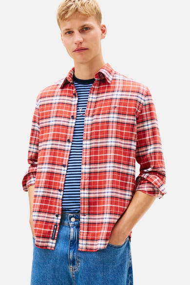 Rood geruit overhemd van TOMMY JEANS, gedragen over een gestreept T-shirt, met een wijde blauwe jeans.