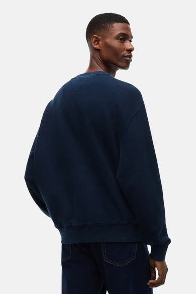 Navy blue waffle-knit crewneck sweatshirt with ribbed cuffs and hem, shown from back on model wearing dark jeans.