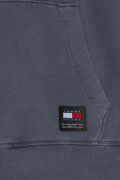 Tommy Jeans blauwe hoodie met kangoeroezak en logo op de voorkant.