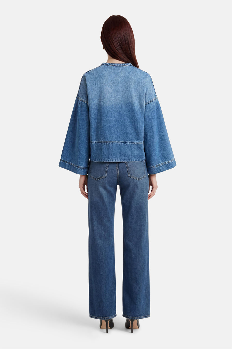 Blouse en denim bleu moyen d'ADORE, à manches évasées et coupe courte sur un pantalon assorti.