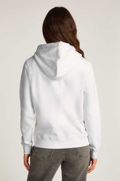 Witte TOMMY JEANS hoodie, van achteren gezien, gedragen met een grijze jeans.