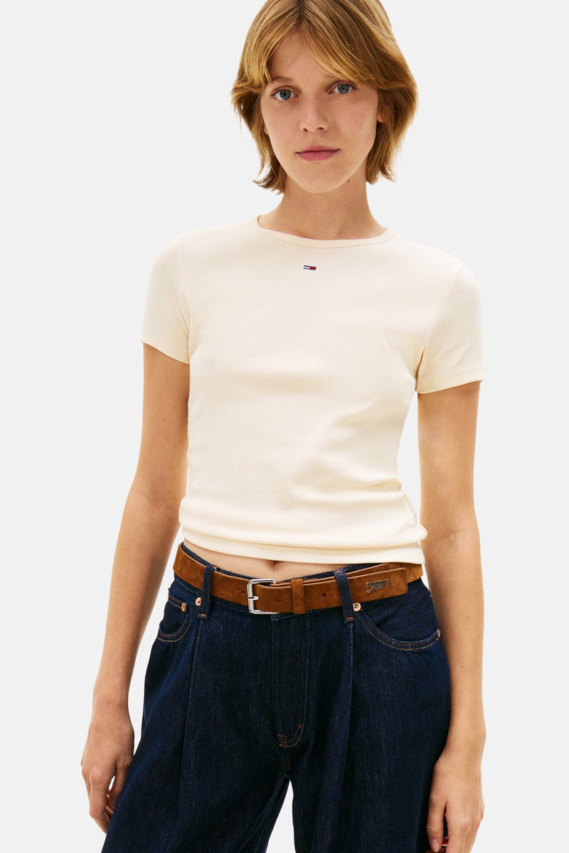 Effenchemise à manches courtes jaune unie, de Tommy Jeans, portée avec un pantalon ample en denim foncé et une ceinture marron.