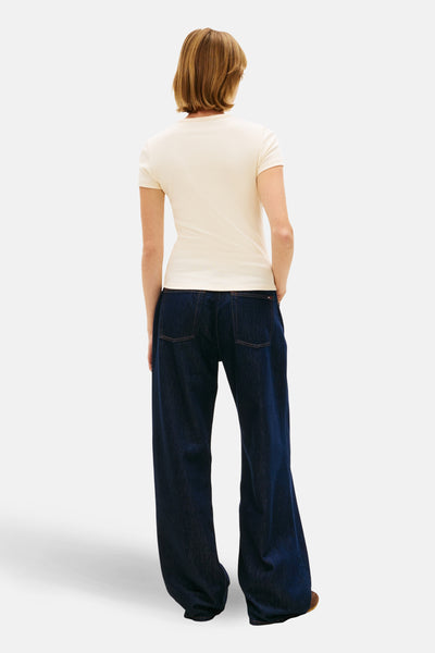 Gele T-shirt met korte mouwen van Tommy Jeans, gedragen met een wijde blauwe jeans.