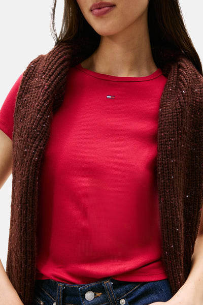Roze T-shirt met korte mouwen van Tommy Jeans, gedragen met een bruin grofgebreid vest.