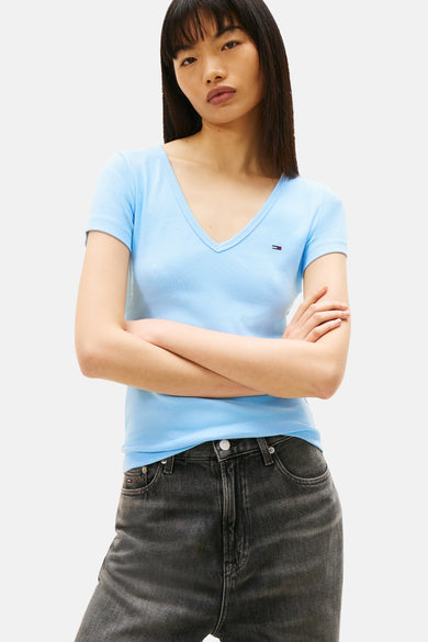 T-shirt bleu à manches courtes de Tommy Jeans, en maille côtelée, porté avec un jean taille haute.