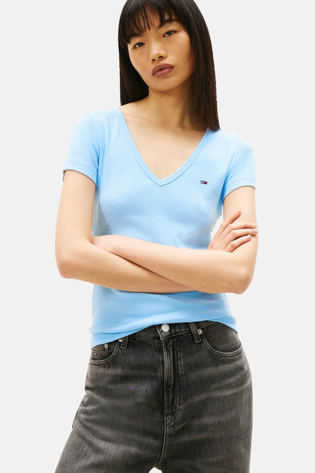 T-shirt bleu à manches courtes de Tommy Jeans, en maille côtelée, porté avec un jean taille haute.