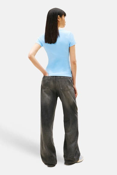 T-shirt bleu à manches courtes de Tommy Jeans, porté avec un jean taille basse délavé, vue de dos.