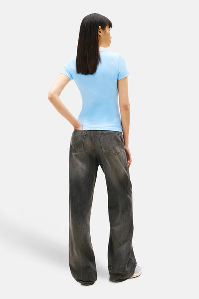 T-shirt bleu à manches courtes de Tommy Jeans, porté avec un jean taille basse délavé, vue de dos.