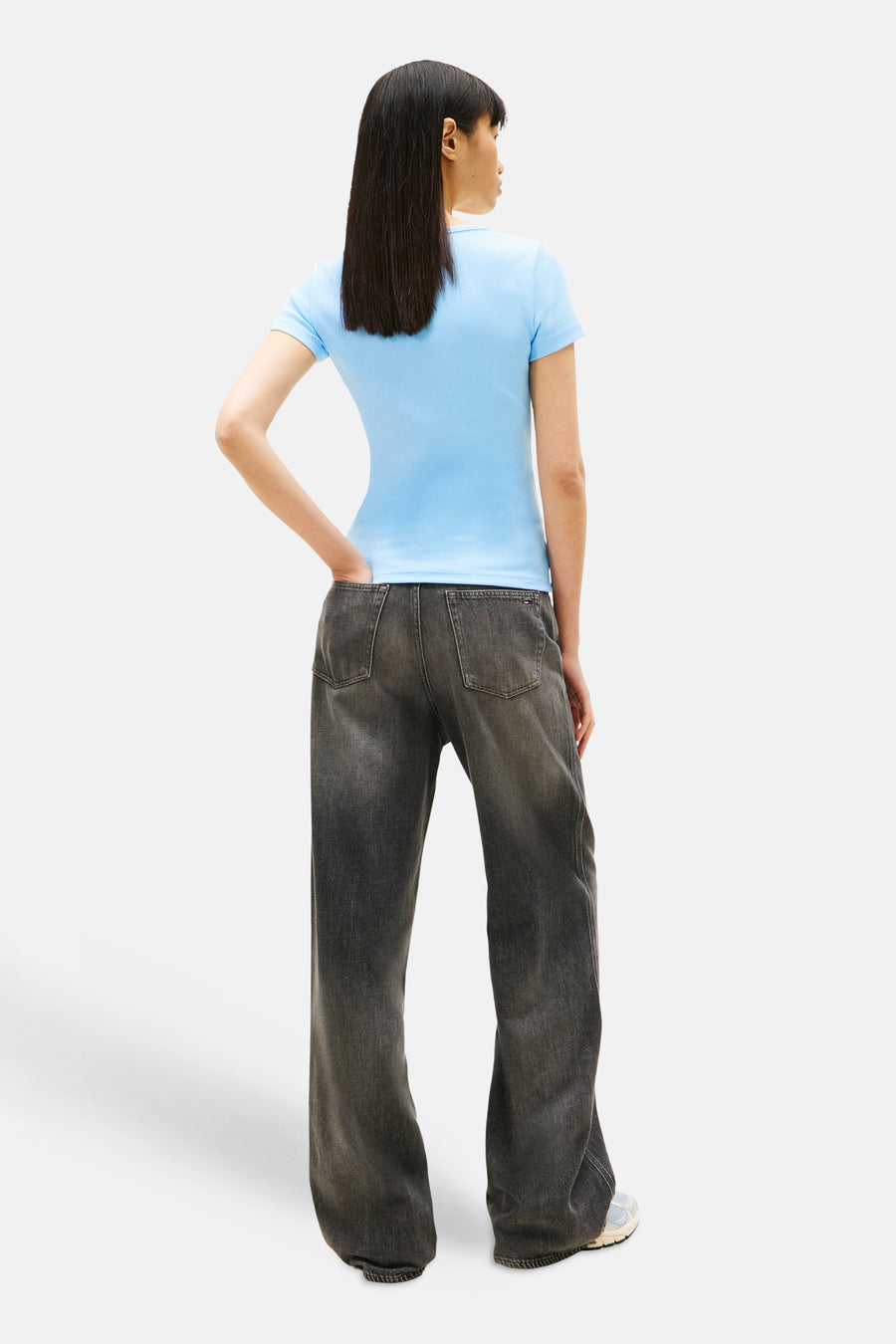T-shirt bleu à manches courtes de Tommy Jeans, porté avec un jean taille basse délavé, vue de dos.