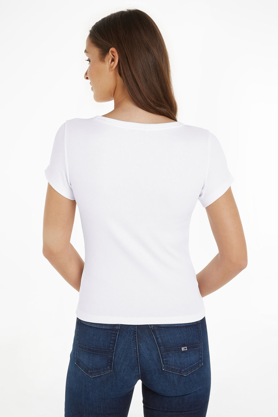Top uni manches courtes blanc de Tommy Jeans, porté avec un jean bleu foncé.
