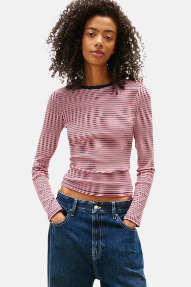 Multikleuren gestreept T-shirt met lange mouwen van TOMMY JEANS gedragen met een schoudertas en een wijde spijkerbroek.