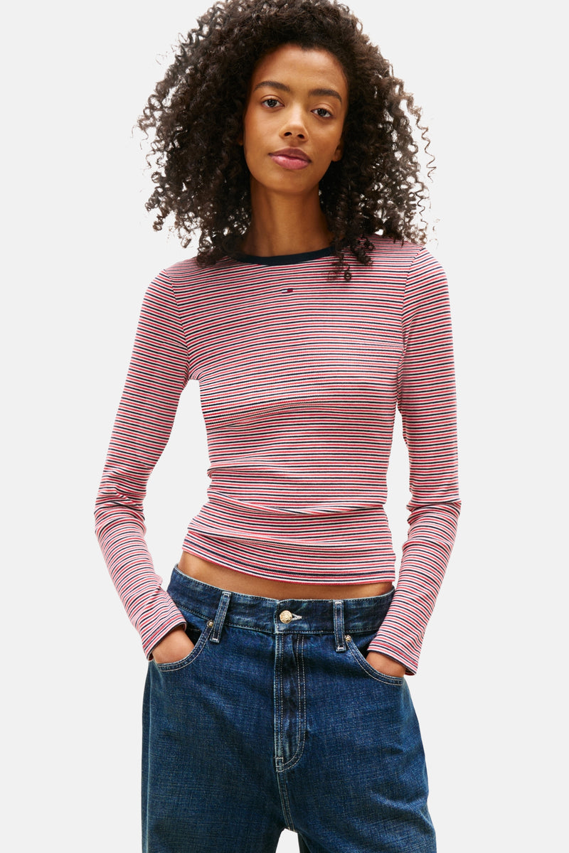 Multikleuren gestreept T-shirt met lange mouwen van TOMMY JEANS gedragen met een schoudertas en een wijde spijkerbroek.