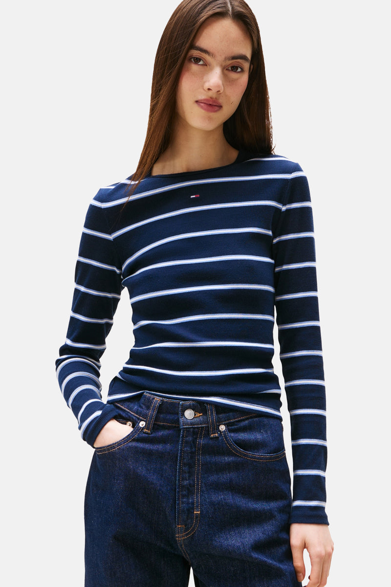 Blauwe T-shirt met lange mouwen en witte strepen van TOMMY JEANS, gedragen met een high-waisted jeans.