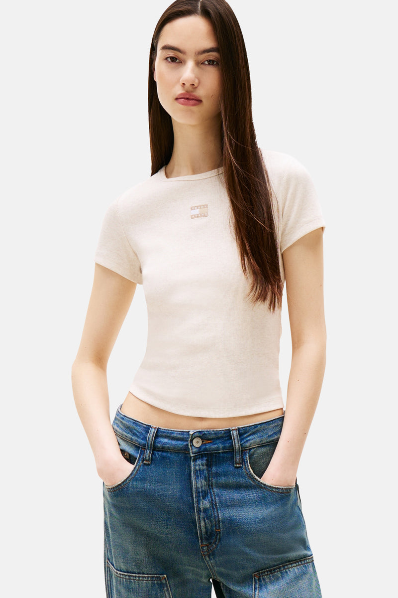 Beige T-shirt met korte mouwen van TOMMY JEANS, in ribgebreide stof, gedragen met een blauwe jeans.