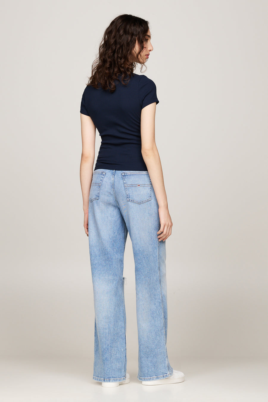 T-shirt bleu à manches courtes de TOMMY JEANS, porté avec un jean ample bleu clair.
