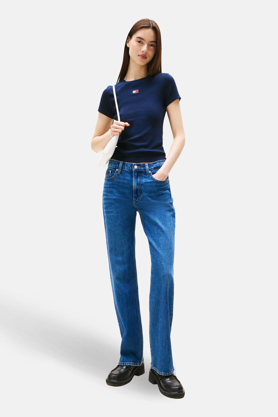 T-shirt à manches courtes bleu de TOMMY JEANS, porté avec un jean et un sac blanc.
