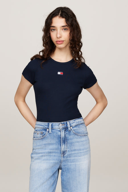 T-shirt bleu à manches courtes de Tommy Jeans, en maille côtelée, porté avec un jean taille haute.