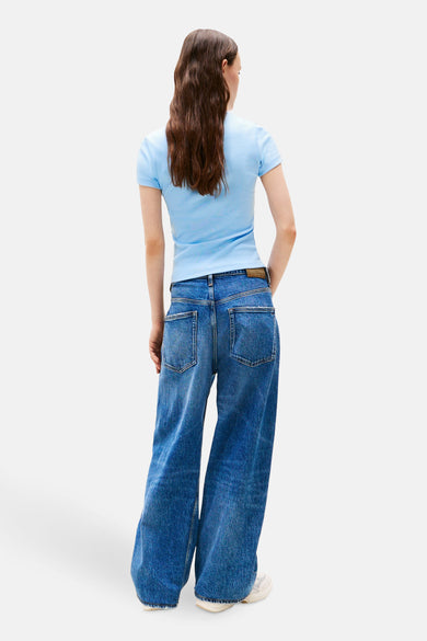 T-shirt bleu à manches courtes de TOMMY JEANS, porté avec un jean large bleu, vue de dos.