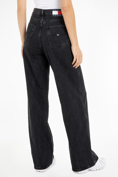 Jean large en denim noir par Tommy Jeans, avec taille haute et coupe ample.
