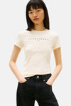 T-shirt jaune à manches courtes de TOMMY JEANS, porté avec un jean noir taille haute.
