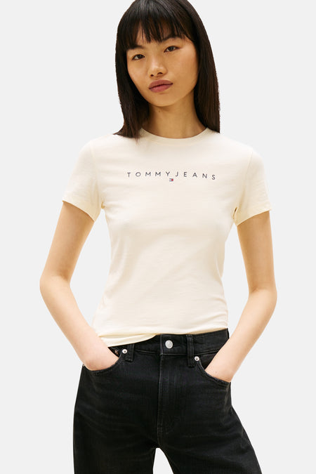 T-shirt jaune à manches courtes de TOMMY JEANS, porté avec un jean noir taille haute.
